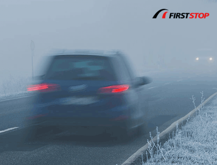 un coche circulando por una carretera con niebla