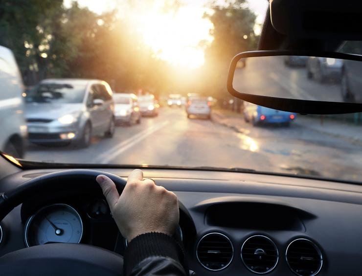 una persona que conduce un coche por una calle de la ciudad